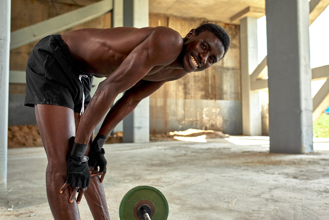 an athletic person lifting weights outside and smiling