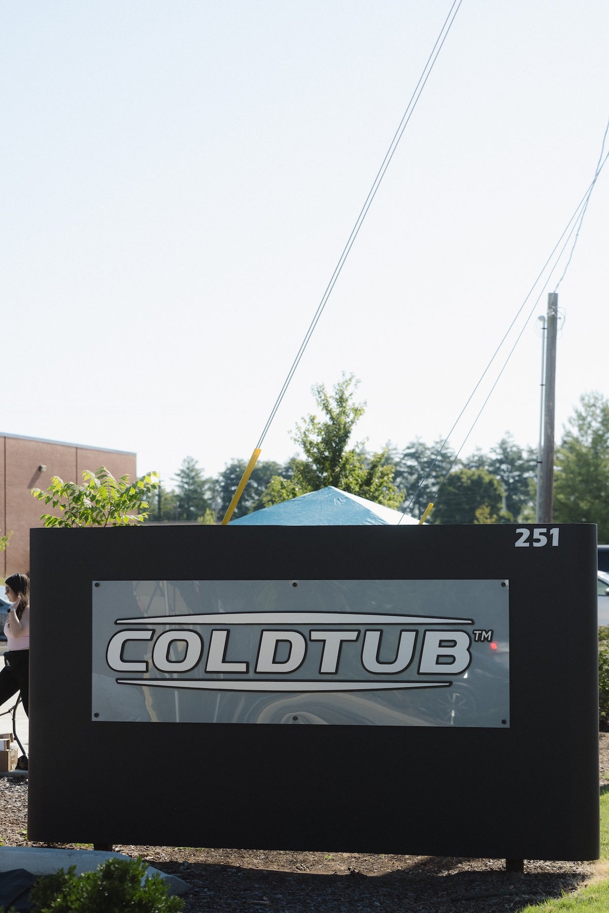 A large outdoor sign displays the word "COLDTUB™" in bold letters, with the number 251 in the top right corner. Trees and a building are visible in the background.